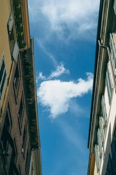 White cloud passing between two buildings in a blue sky Stock Photos