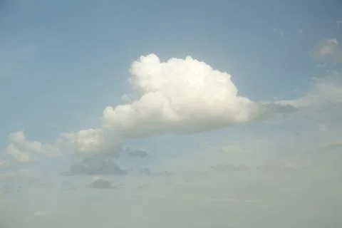 White cloud in the soft blue sky. Dramatic sky background. Stock Photos