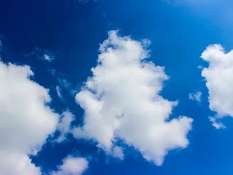 White clouds against a dark blue sky. Stock Photos