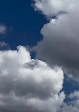 White clouds against a deep blue sky. Dramatic cloudscape with natural daylig Stock Photos
