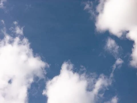 White Clouds Along Both Edges of a Blue Sky Opening Stock Photos