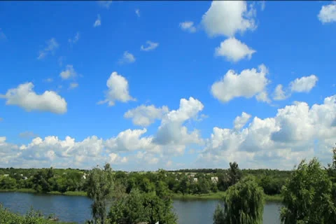 White clouds and blue sky over the river timelapse Stock Footage 26050065