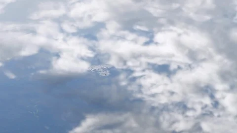 White Clouds and Blue Sky Reflected in Water (Slow Motion) Stock Footage 124595757