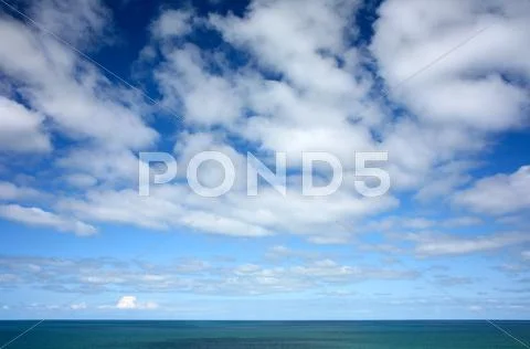 White clouds and blue sky high above the atlantic ocean. Stock-Fotos