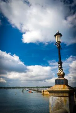 White clouds and blue sky reflect on calm water at Sandbanks, Poole, Dorset Stock Photos