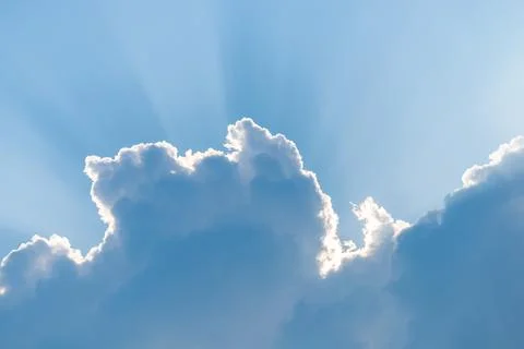 White clouds and blue sky with ray of sun coming through 写真素材