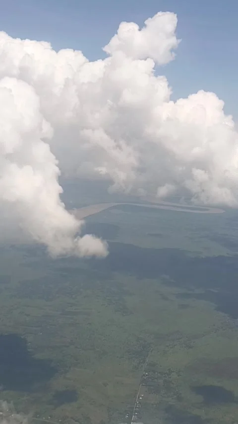 White clouds and the Kapuas River are visible from the plane window Stock Footage 311307943