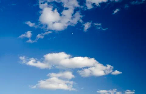 White clouds and the moon in the deep blue sky Stock Photos