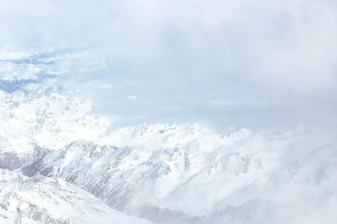 White clouds and mountain pics, a view from an airplane window. Top view Stock-Fotos