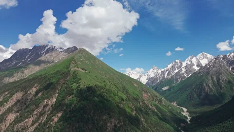 White clouds are slowly passing over a green mountain valley Stock-Footage 289658700