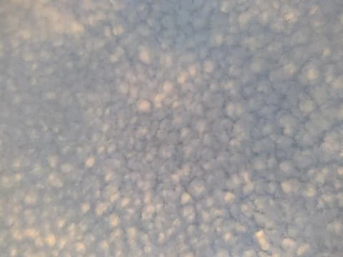 White clouds are small spots on the blue sky. Photos