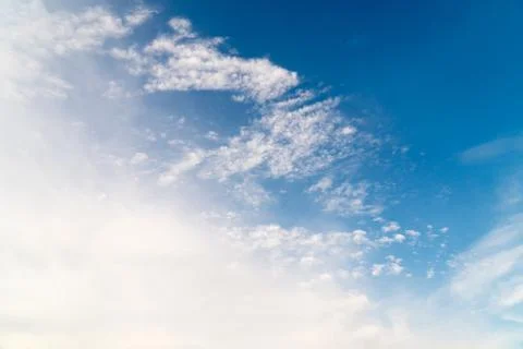 White clouds on a background of blue sky on a sunny day. Stock Photos