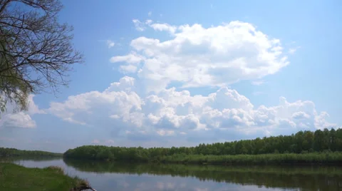 White clouds on a background of a flowing river. Timelapse. Stock Footage 37396275