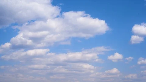 White clouds on a blue sky against trees and mountains in early spring Stock Footage 111144952