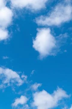White clouds in the blue sky on a bright sunny day. Stock Photos