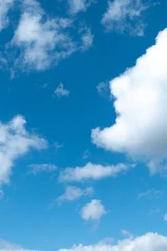 White clouds in the blue sky on a bright sunny day. Stock Photos
