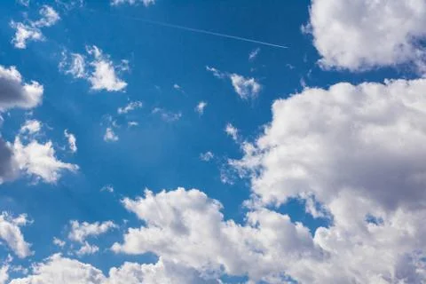 White Clouds Blue Sky Fluffy Sun Flare Airplane Trail  Sunny Daytime Texture  Stock Photos