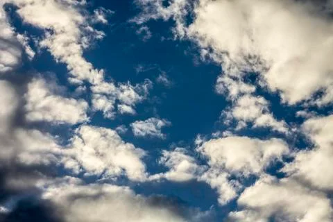 White clouds in the blue sky in the form of a whirlpool Stock Photos