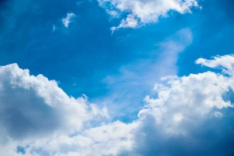 White clouds in the blue sky, light on the clouds in the sky Stock Photos