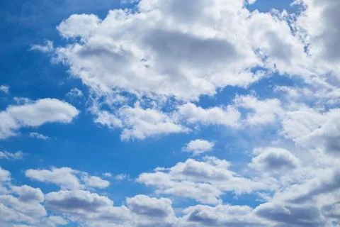 White clouds in the blue sky, light on the clouds in the sky Stock Photos