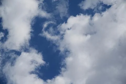 White clouds in the blue sky, light on the clouds in the sky Stock Photos