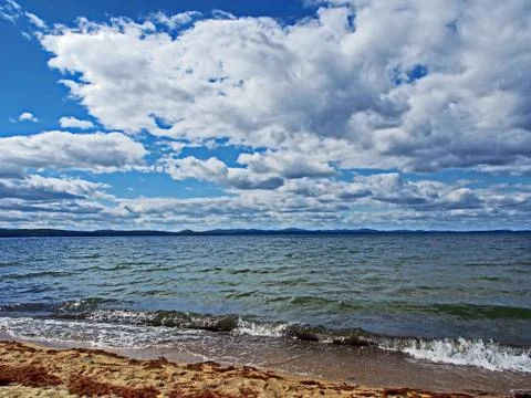White clouds in the blue sky over the lake in the early morning Stock Photos