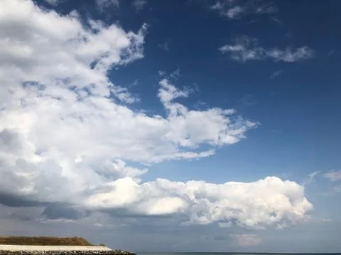 White clouds in the blue sky over the sea in summer. There is a place for ins 스톡 사진