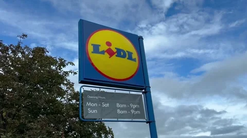White clouds in a blue sky passing behind a Lidl sign. Stock Footage 317516751