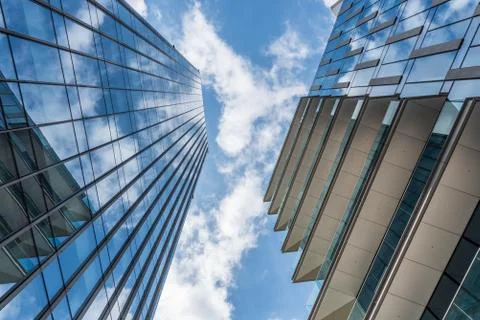 White clouds in a blue sky reflected in the windows of skyscrapers Stock Photos