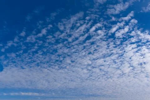 White clouds in the blue sky. Spring sky with moving clouds. Stock Photos