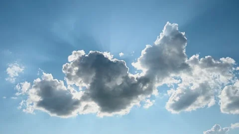 White clouds on blue sky in summer. Sun shining behind dark clouds in afternoon. Stock Footage 157569239