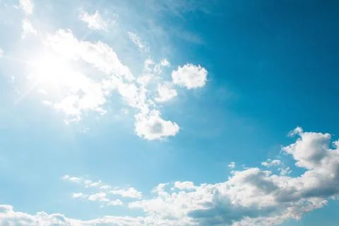 White Clouds on the blue sky with sun shines Stock Photos