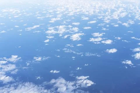 White clouds in a blue sky, view from the porthole, view from above Stock Photos
