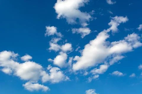 White clouds on a clear blue sky background Stock Photos