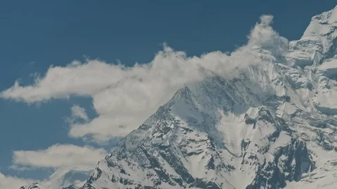 White clouds crawl over enormous snow ridge of Annapurna II mountain, Nepal Stock Footage 124677322