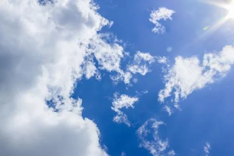 White clouds in a deep blue sky with sunlight. Clean weather background Stock Photos