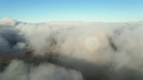 White clouds of dense fog move quickly over sea and coastline blue sky Stock Footage 142952286