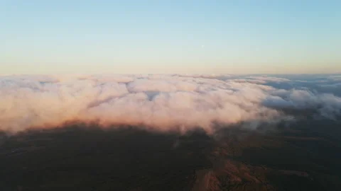 White clouds of dense fog move quickly over sea and coastline blue sky Stock Footage 142953558