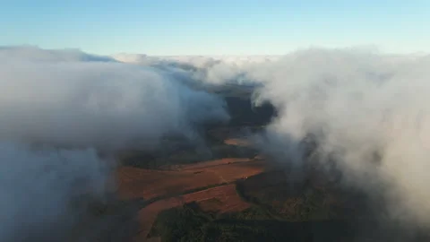 White clouds of dense fog move quickly over sea and coastline blue sky Stock Footage 142955076