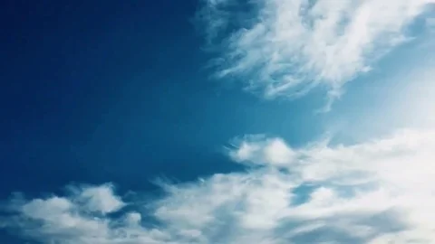 White clouds disappear in the hot sun on blue sky. Time-lapse motion clouds blue Stock Footage