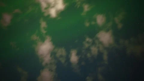 White clouds drift across a stary night sky as brightly colored aurora Northern Stock Footage 339733480