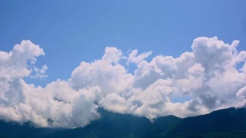 	 White clouds drift over alpine peaks under a blue sky in a summer timelapse fr Stock Footage 293249758