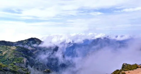 White clouds drift over mountain peaks in Madeira Stock Footage 313842679