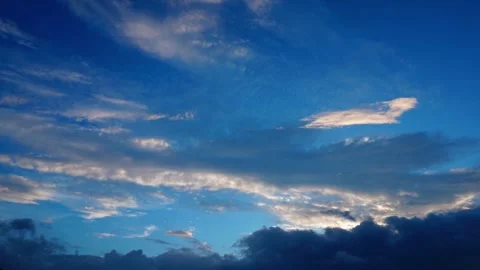 White clouds drifting slowly across a vibrant blue sky during a sunny afternoon Stock Footage 347038598