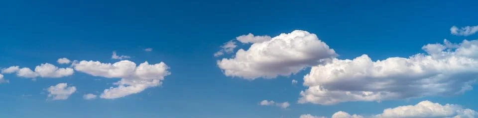 White clouds float across the blue sky Stock Photos