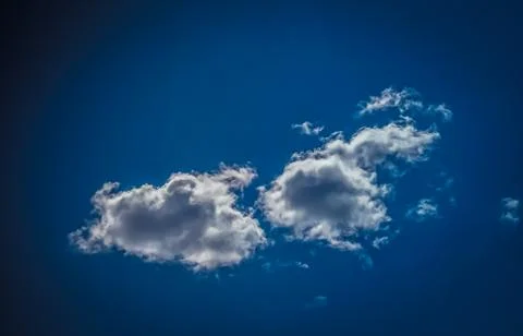 White clouds float across the blue sky Stock Photos