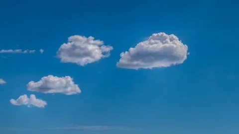 White clouds float across the blue sky Stock Photos