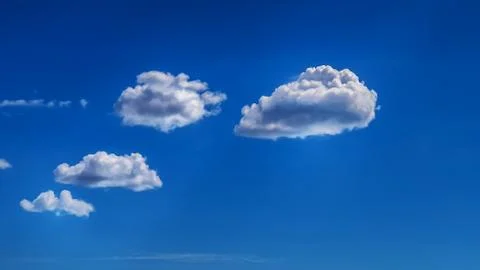 White clouds float across the blue sky Stock Photos