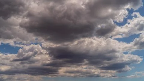 White clouds float across the blue sky above the sea Stock Photos