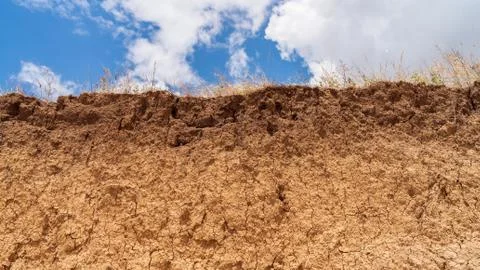 White clouds float across the blue sky over the cliff Stock Photos